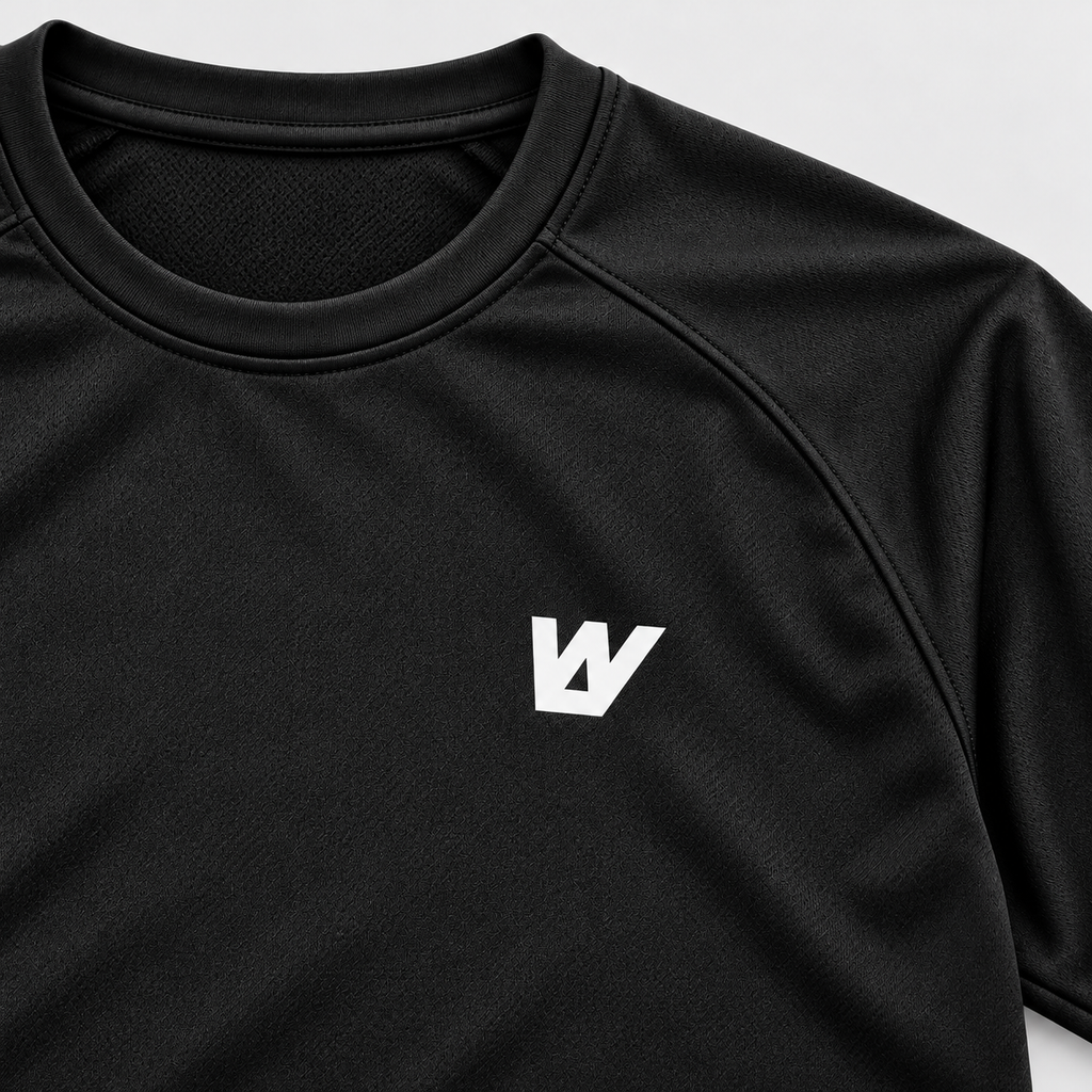Detalle del logo W blanco en el pecho y el tejido negro de la camiseta WalkBCN. Mockup.